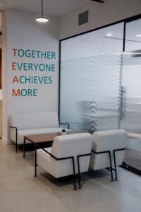 Contemporary office lounge in Dubai featuring white armchairs and a motivational quote on the wall.